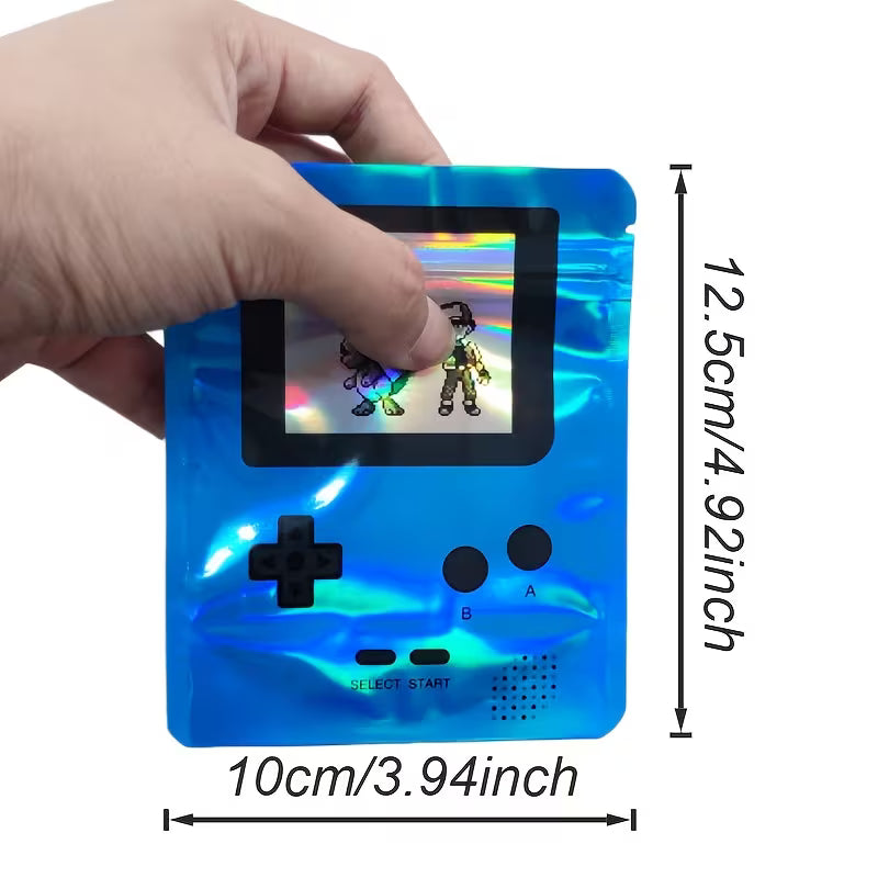 Handheld gaming console with a small screen displaying graphics, held by a hand, with dimensions indicated.