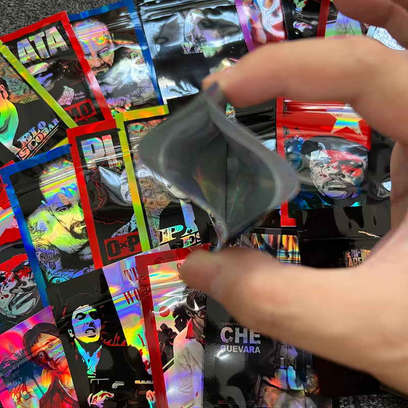 Hand opening a colorful foil pack with images of people on it.