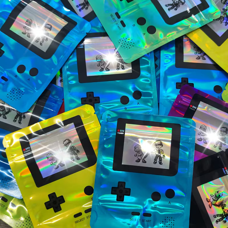 Colorful handheld gaming devices with transparent plastic wrap on a multicolored background